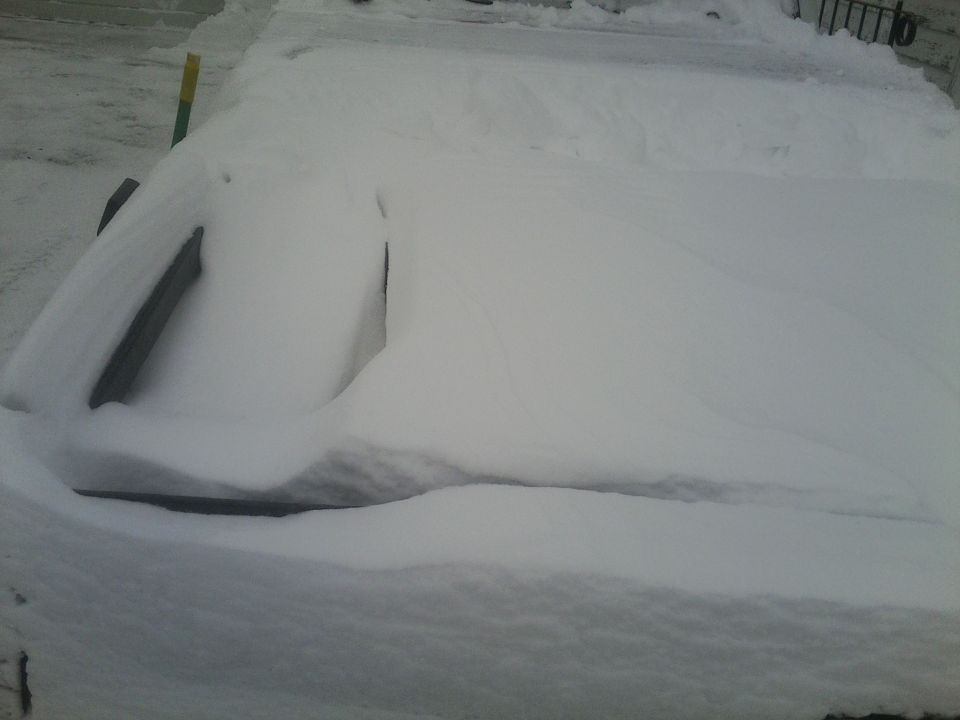 Truck covered in snow, partially obscuring the front end and windshield