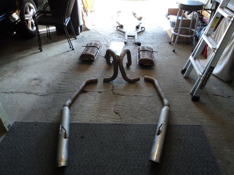2004 Mercury Grand Marquis - Various components of a car's exhaust system are disassembled and arranged on the ground.