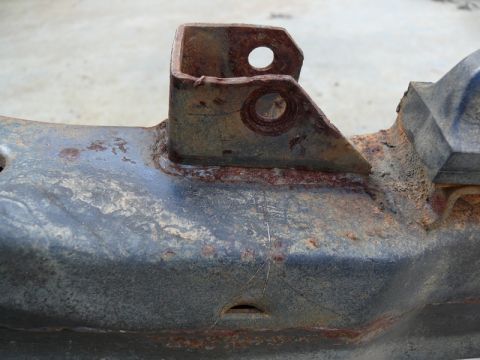 1976 Chevrolet Corvette - Close-up of a heavily rusted metal bracket on a vehicle frame, showing significant corrosion.
