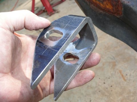 1976 Chevrolet Corvette - A metal bracket with two holes is held in a hand, with the Supermotors.net logo in the lower right corner.
