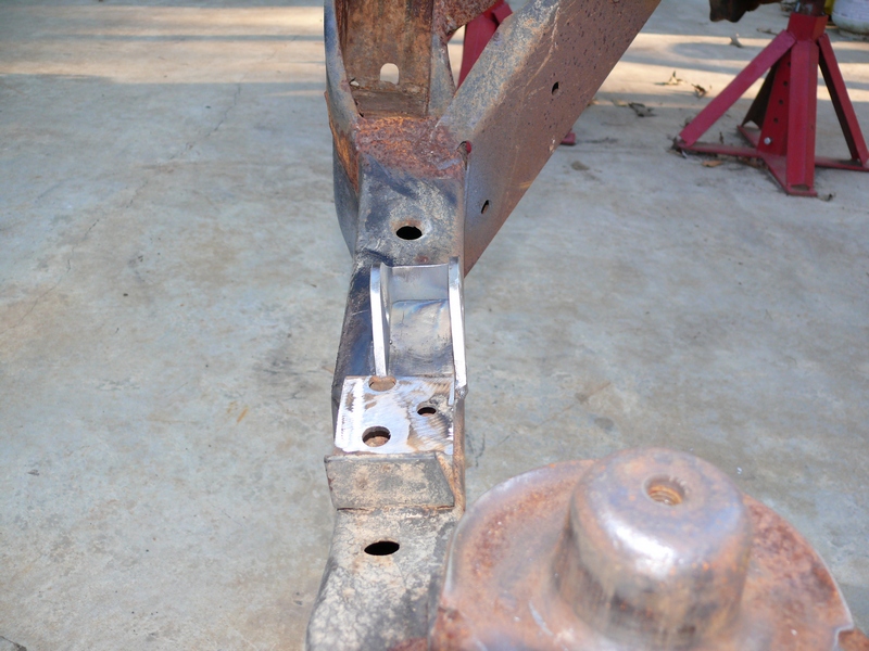 Rusted vehicle frame section with welded metal brackets and a circular component