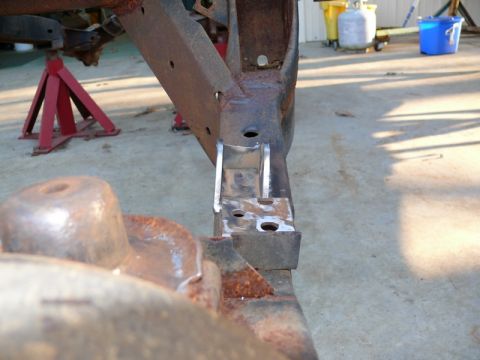 1976 Chevrolet Corvette - Close-up view of a vehicle's rusted frame section, showing repair work and support stands.