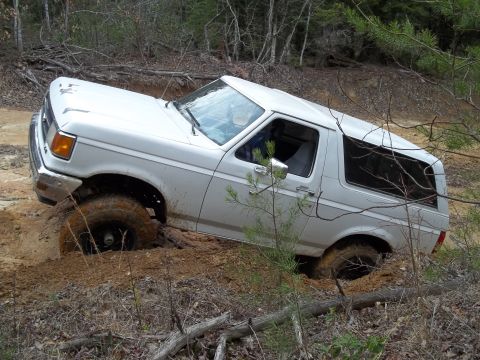1990 Ford Bronco - This white 1987 Ford Bronco is stuck in the mud while off-roading.