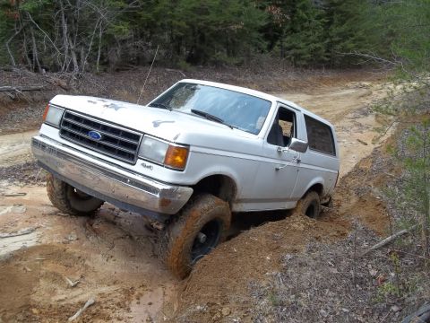 1990 Ford Bronco - This 1990 Ford Bronco navigates a challenging muddy off-road path.