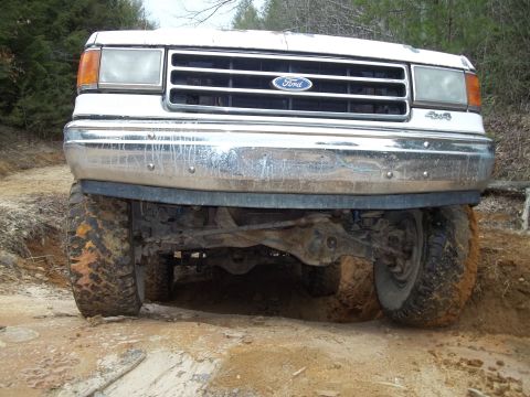 1990 Ford Bronco - Front view of a 1990 Ford Bronco navigating rough terrain.