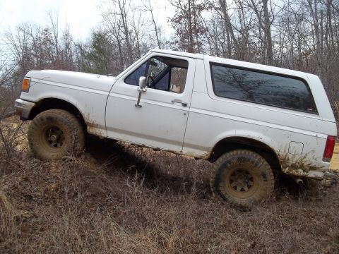 1990 Ford Bronco - 1990 Ford Bronco navigating rough terrain off-road.