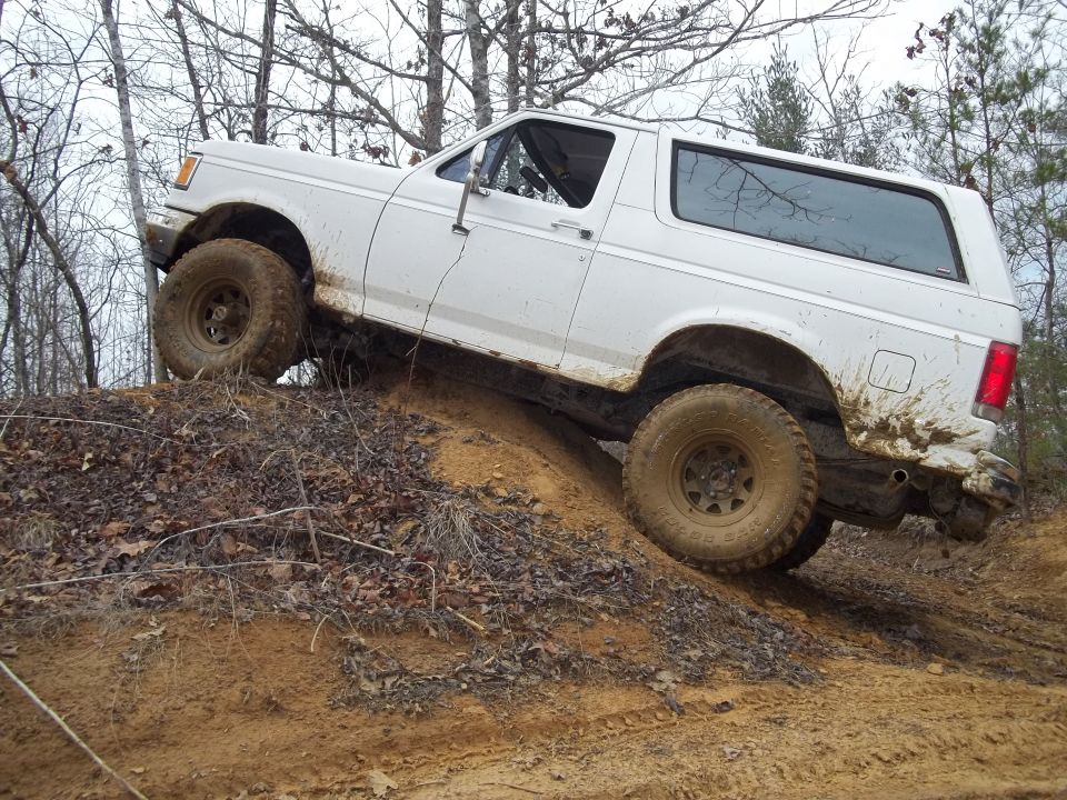 1990 Ford Bronco climbing a steep dirt hill off-road