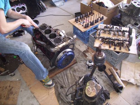 1995 Ford Probe - Engine components are disassembled and organized on the floor for repair or maintenance.
