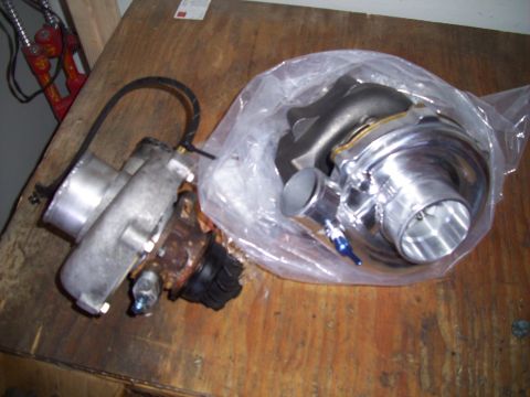 1995 Ford Probe - Two turbochargers are displayed on a wooden table, one still in its packaging.