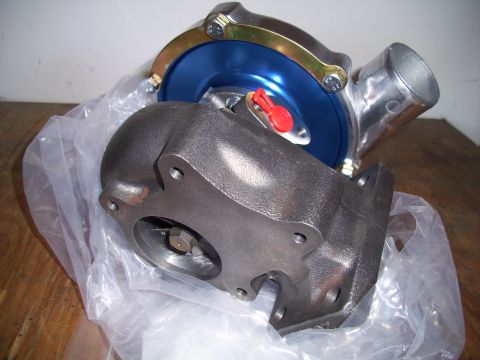 1995 Ford Probe - A turbocharger part is shown in a plastic bag on a wooden surface.