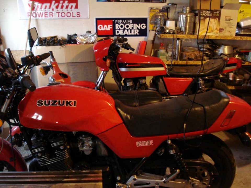 Red Suzuki GS1100E motorcycle side view, with another red motorcycle behind it