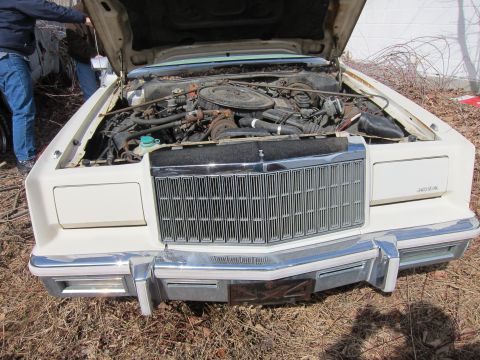 1991 Ford LTD Crown Victoria - Front view of a white car with hood open, revealing the engine and grille.