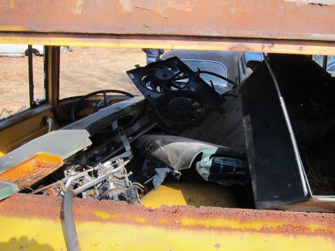 1991 Ford LTD Crown Victoria - A cluttered view of a car's interior, filled with various parts and debris, with another vehicle in the background.