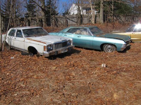 1991 Ford LTD Crown Victoria - A white 1979 Mercury Grand Marquis sedan sits in a yard next to other vehicles.