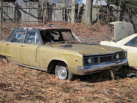 1991 Ford LTD Crown Victoria - This weathered sedan sits abandoned in a yard, showing signs of significant disrepair and missing components.