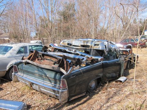 1991 Ford LTD Crown Victoria - Junked Lincoln Continental in a yard, other vehicles visible.