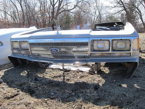 1991 Ford LTD Crown Victoria - The front clip of a silver Ford Crown Victoria, likely from the early 1980s, sits in a junkyard.