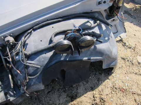 1991 Ford LTD Crown Victoria - Close-up of car horns and wiring harness, likely from a vehicle's front end.