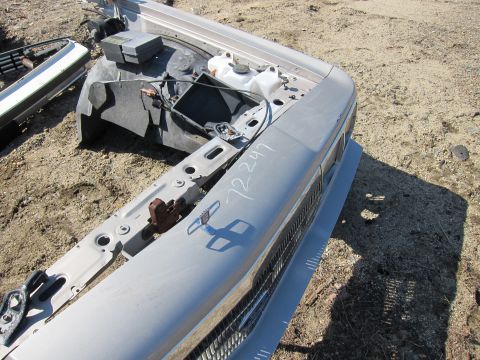 1991 Ford LTD Crown Victoria - Junkyard scene with various car parts, including a front grille and hood section.