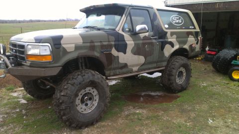 1995 Ford Bronco - Camouflaged 1995 Ford Bronco modified for off-road use with large tires.