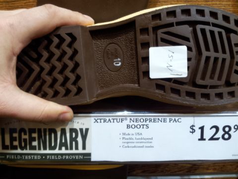 2008 GMC Sierra 3500 - A hand holds the sole of a boot, displaying its tread pattern and a price tag of $128.99.