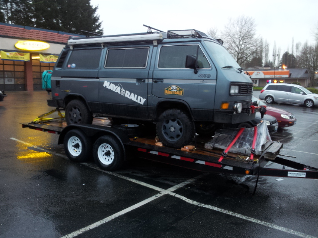 Gray Volkswagen Vanagon on a trailer, with "MAYA RALLY" graphics and roof rack