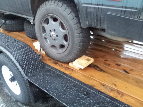 2008 GMC Sierra 3500 - A Volkswagen Vanagon is being transported on a wooden trailer, secured with chocks under the wheel.