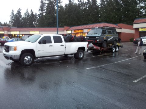 2008 GMC Sierra 3500 - A white GMC Sierra 3500 dually truck tows a trailer carrying a grey van. The truck appears to be a 2007 model.