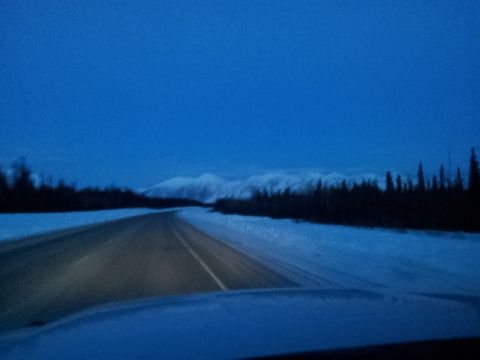 2008 GMC Sierra 3500 - A desolate highway stretches through a snow-covered landscape under a deep blue twilight sky.