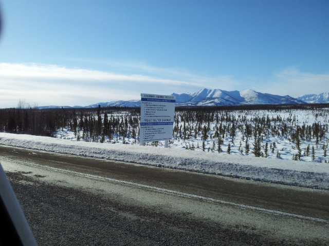 Sign with project details in a snowy landscape with mountains