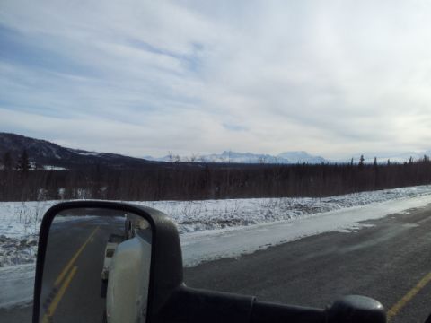 2008 GMC Sierra 3500 - Driving through a winter landscape with snow-covered ground and mountains in the distance.