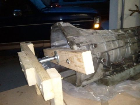 1994 Ford Bronco - Transmission housing resting on a wooden stand.