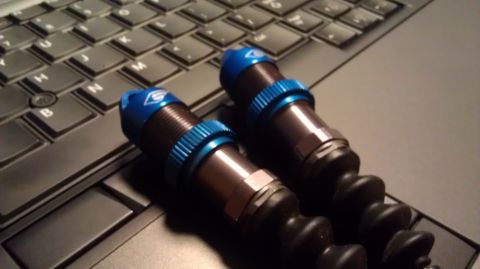 1996 Ford Bronco - Close-up view of two RC car shock absorbers resting on a laptop keyboard.