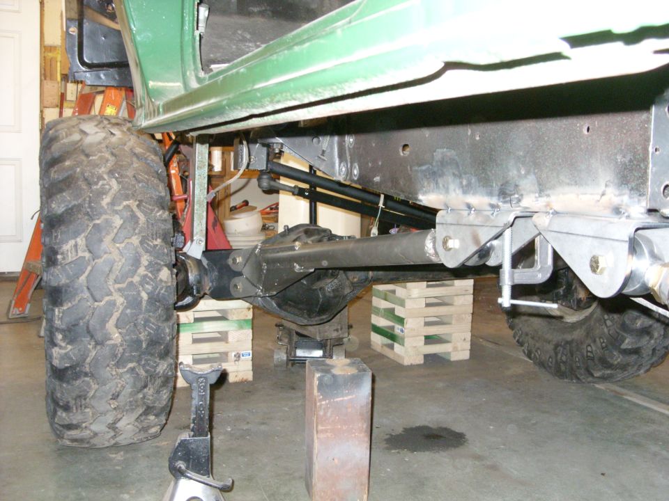 Green truck frame with large tire and suspension components visible