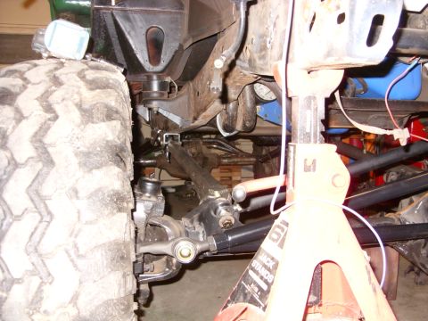 1967 Ford F-250 - The underside of a vehicle, showing the suspension components and frame, supported by a jack stand.