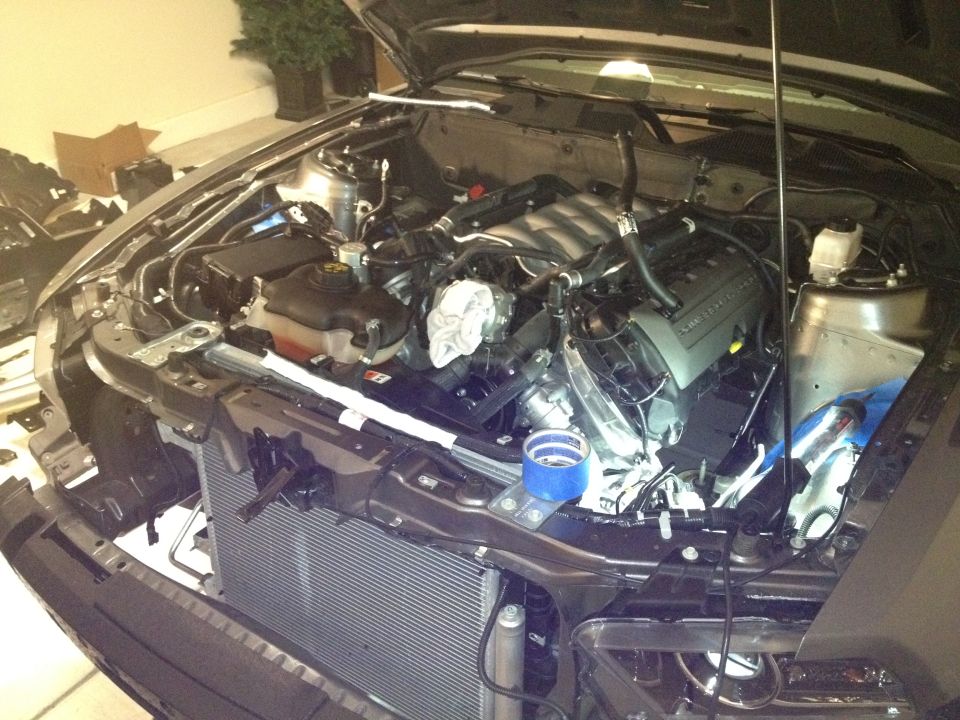 2013 Ford Mustang engine bay with hood open, showing engine components and radiator