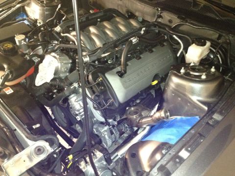2013 Ford Mustang - Close-up view of a car's engine compartment, showing various mechanical components and wiring.