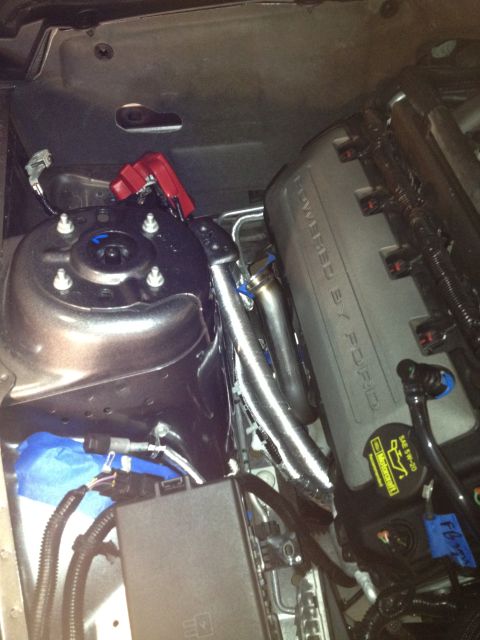 2013 Ford Mustang - Close-up of the engine bay in a 2013 Ford Mustang, showing the "Powered by Ford" valve cover and exhaust manifold.