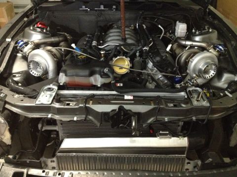 2013 Ford Mustang - The engine bay shows a complex setup with twin turbochargers and an upgraded intercooler.