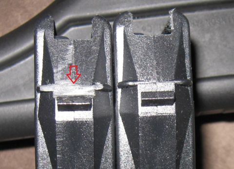 2000 Ford Crown Victoria - Comparison of two plastic clips, highlighting wear on the left one with a red arrow.