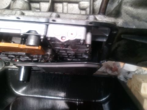 1994 Ford Bronco - Transmission pan and filter removed for service, revealing the internal workings and drained fluid.