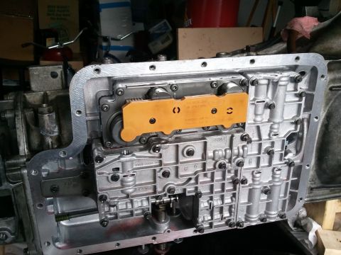 1994 Ford Bronco - Close-up of a transmission valve body, an orange component and visible Ford branding.