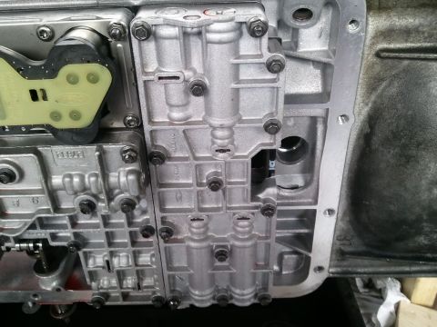 1994 Ford Bronco - Close-up of a transmission valve body, showing internal components and a visible Ford logo.