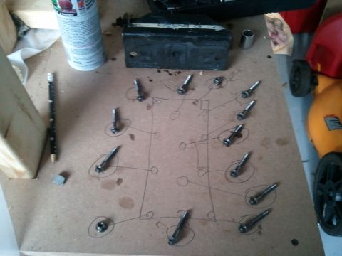 1994 Ford Bronco - A diagram of bolts is laid out on cardboard, with a spray can and pencil nearby.