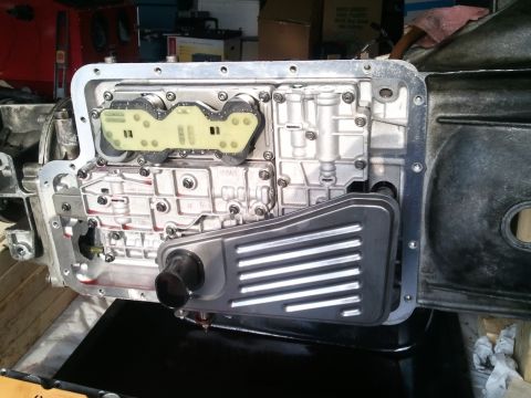 1994 Ford Bronco - Close-up of a vehicle transmission's valve body and filter assembly, with internal parts exposed.
