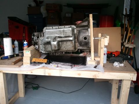 1994 Ford Bronco - A Ford transmission is shown disassembled on a workbench, surrounded by tools and parts.