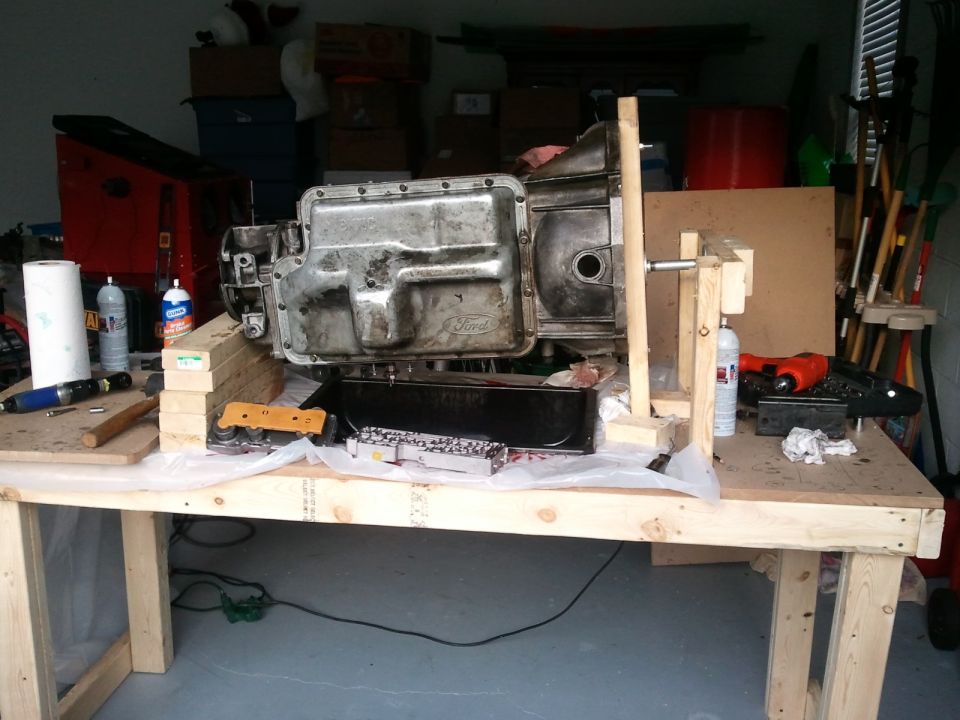 Ford transmission on workbench with tools