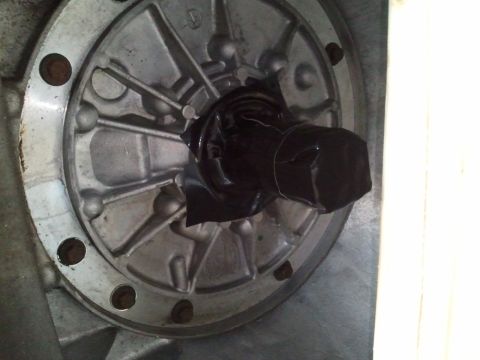 1994 Ford Bronco - This image shows a close-up of a metal component, possibly from a vehicle's drivetrain, with a shaft covered in black tape.