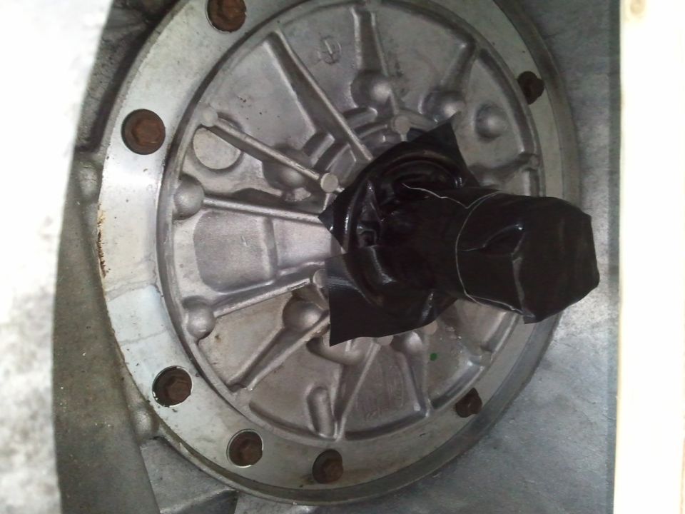 Transmission housing with bolted flange and black taped shaft