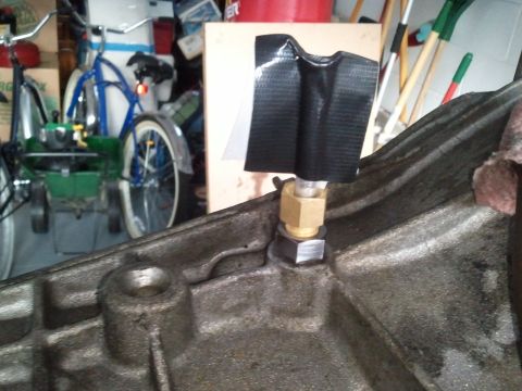 1994 Ford Bronco - A close-up of a transmission housing shows a brass fitting secured with duct tape.
